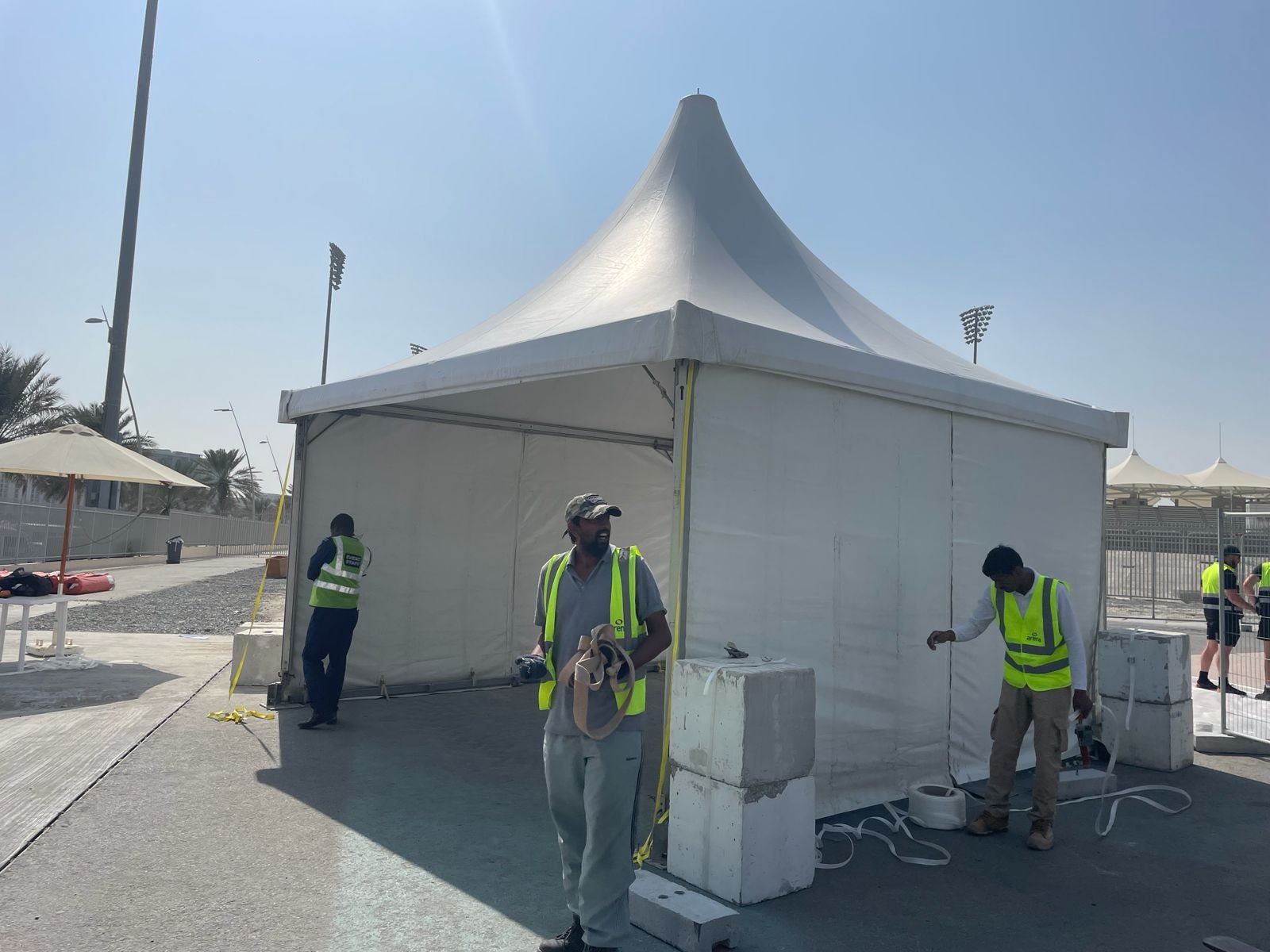 Toko crew installing a white pagoda tent on site